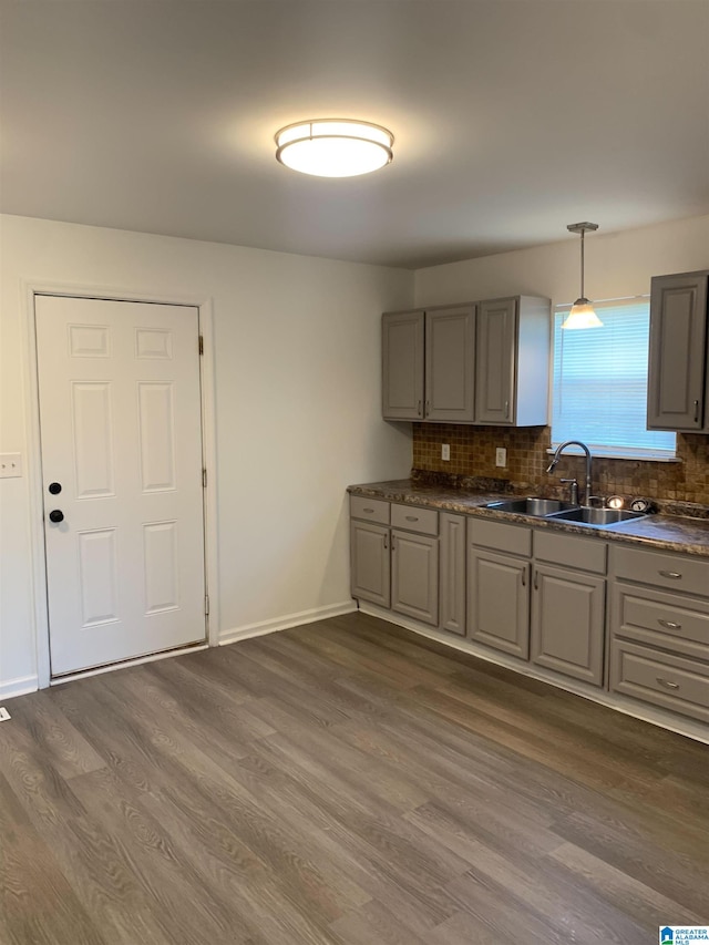 kitchen with sink, decorative light fixtures, backsplash, and dark hardwood / wood-style floors