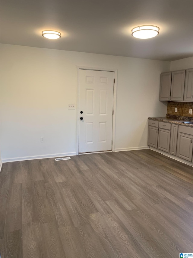 unfurnished dining area featuring dark wood-type flooring