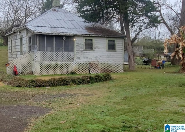 back of property featuring a yard and a sunroom