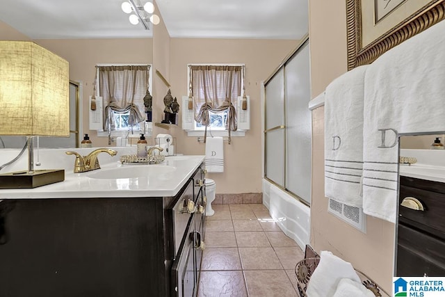 full bathroom featuring combined bath / shower with glass door, vanity, toilet, and tile patterned floors