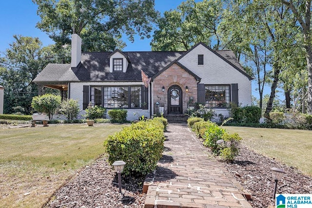 tudor home featuring a front lawn