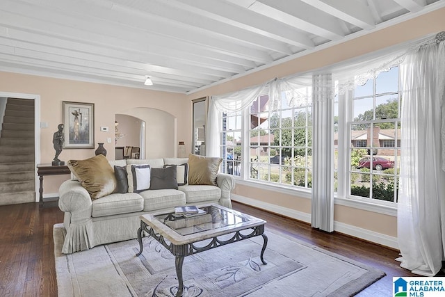 living room featuring beamed ceiling and dark hardwood / wood-style flooring