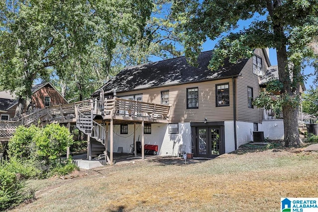 back of house with central air condition unit, a wooden deck, a lawn, and french doors