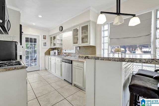 kitchen with stainless steel appliances, sink, light stone countertops, decorative backsplash, and white cabinets