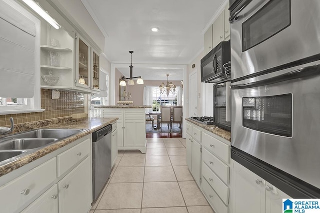 kitchen featuring decorative light fixtures, light tile patterned floors, appliances with stainless steel finishes, a chandelier, and white cabinets