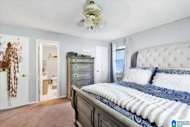 carpeted bedroom featuring ensuite bathroom and a textured ceiling