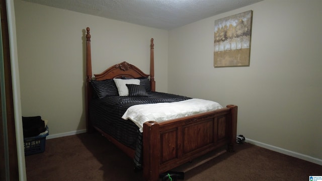 bedroom with dark colored carpet and a textured ceiling