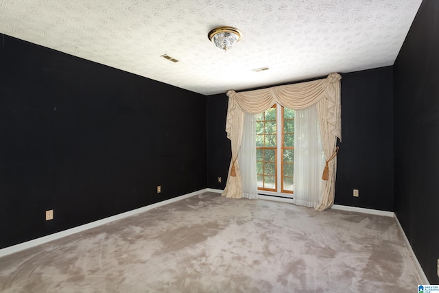 empty room with a baseboard heating unit, a textured ceiling, and carpet flooring