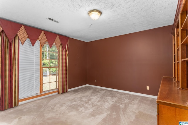 carpeted spare room with a textured ceiling