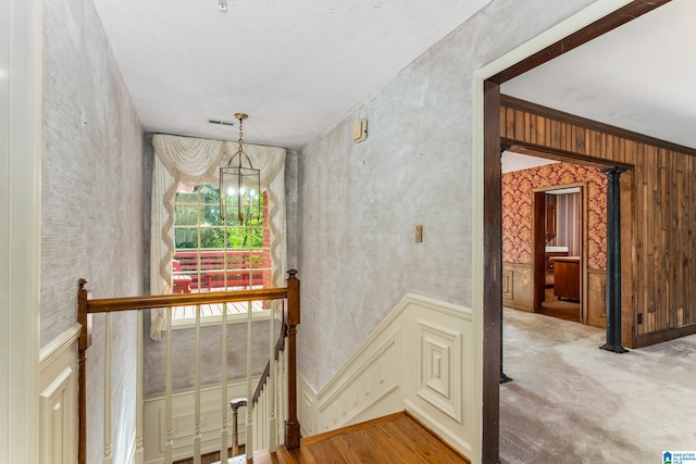 stairs with a chandelier and carpet flooring