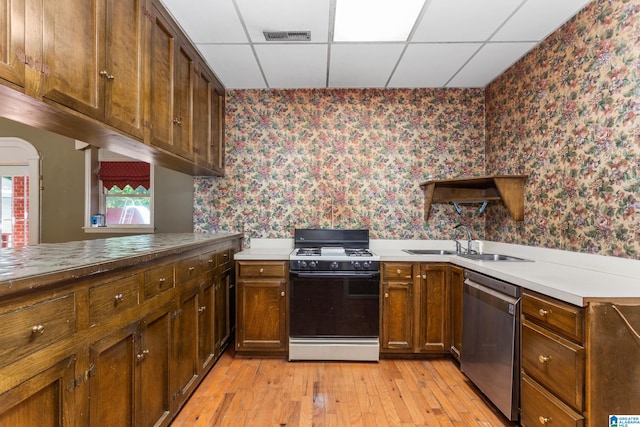 kitchen featuring dishwasher, range with gas stovetop, sink, and a paneled ceiling