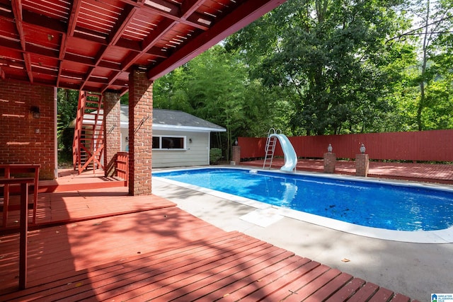 view of swimming pool featuring a water slide and a deck