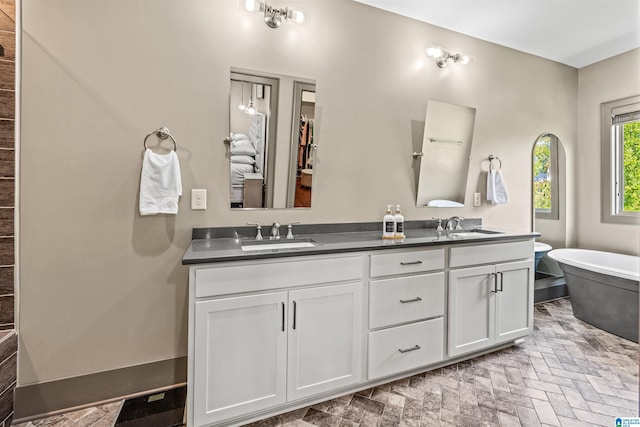 bathroom with vanity and a tub