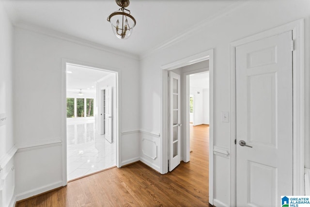 interior space with ornamental molding, hardwood / wood-style floors, and a notable chandelier