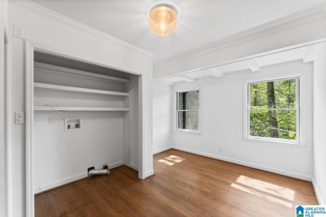 unfurnished bedroom with dark wood-type flooring, a closet, beam ceiling, and crown molding