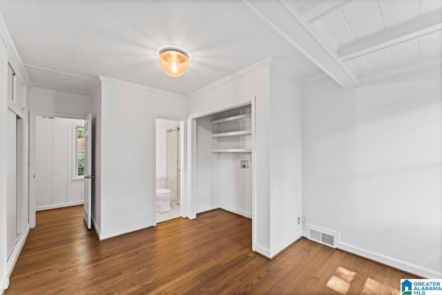 unfurnished bedroom featuring beamed ceiling, ornamental molding, a closet, dark hardwood / wood-style floors, and ensuite bathroom