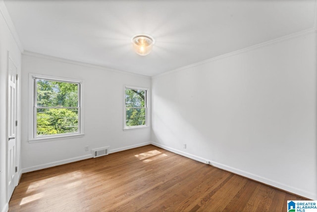 unfurnished room featuring ornamental molding and light hardwood / wood-style flooring