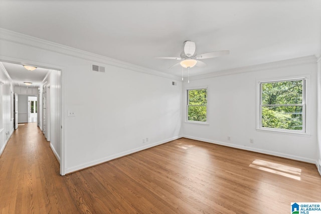 spare room featuring crown molding, hardwood / wood-style flooring, a wealth of natural light, and ceiling fan