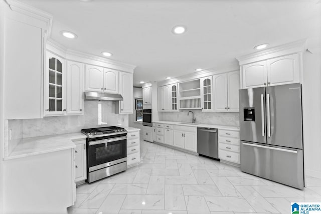 kitchen with sink, appliances with stainless steel finishes, white cabinets, and tasteful backsplash