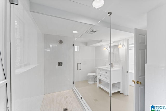 bathroom featuring tile patterned flooring, a shower with door, toilet, tile walls, and vanity