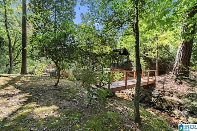 view of yard featuring central AC unit and a deck