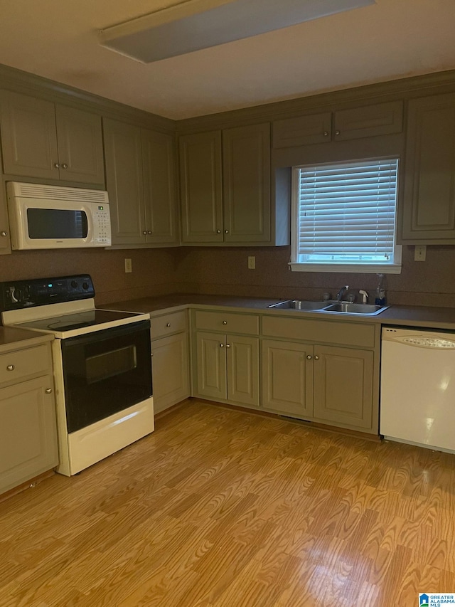 kitchen featuring white appliances, sink, and light hardwood / wood-style floors