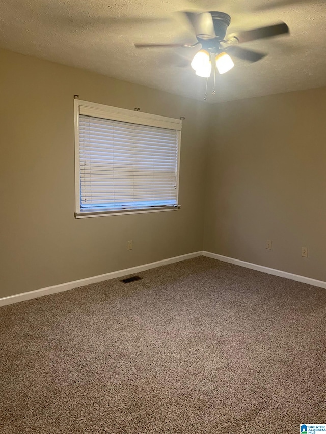 unfurnished room featuring ceiling fan, carpet floors, and a textured ceiling