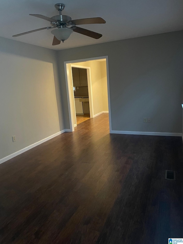 unfurnished room with dark wood-type flooring and ceiling fan