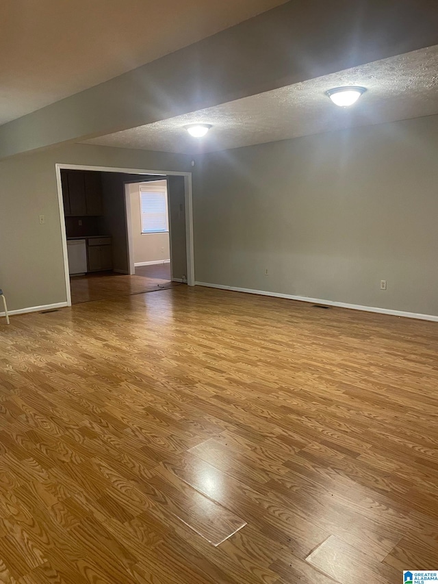 spare room featuring a textured ceiling and light hardwood / wood-style flooring