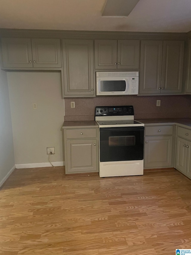 kitchen featuring light wood-type flooring, white appliances, and gray cabinetry