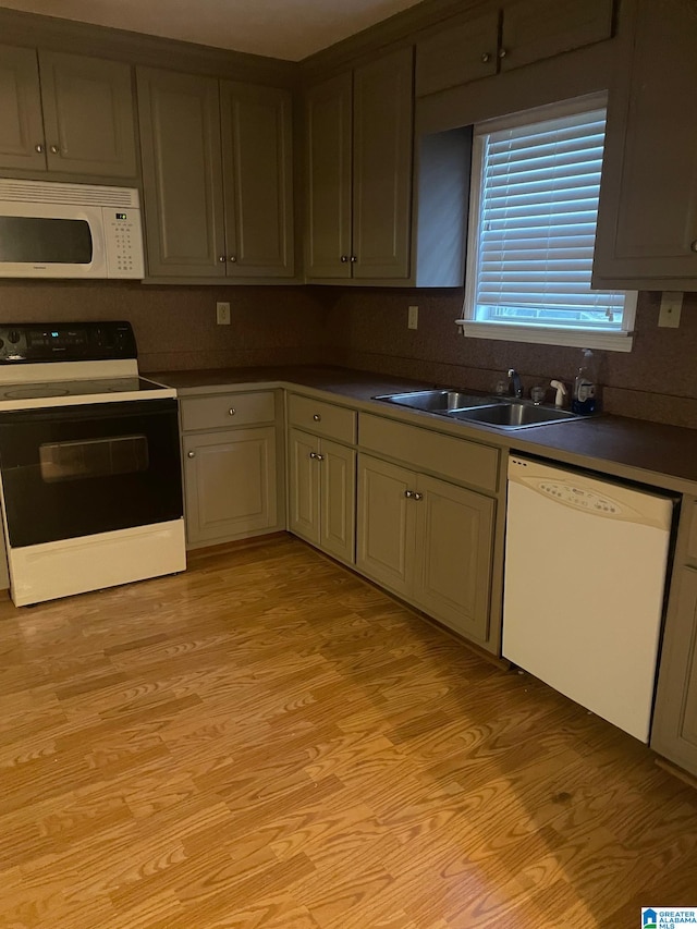 kitchen with sink, white appliances, and light hardwood / wood-style floors