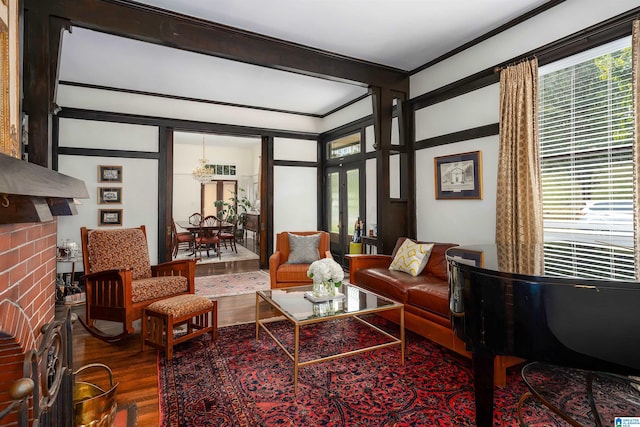 living room featuring crown molding, hardwood / wood-style floors, and a brick fireplace