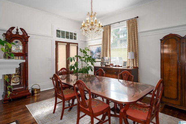 dining space featuring dark wood-type flooring, a chandelier, and ornamental molding