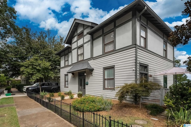 view of front facade featuring stucco siding and fence