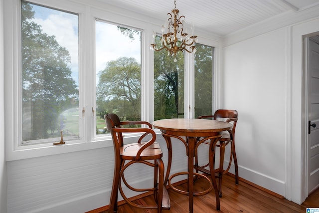 dining space with crown molding, a chandelier, and hardwood / wood-style flooring