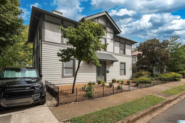 contemporary home with a chimney and a fenced front yard
