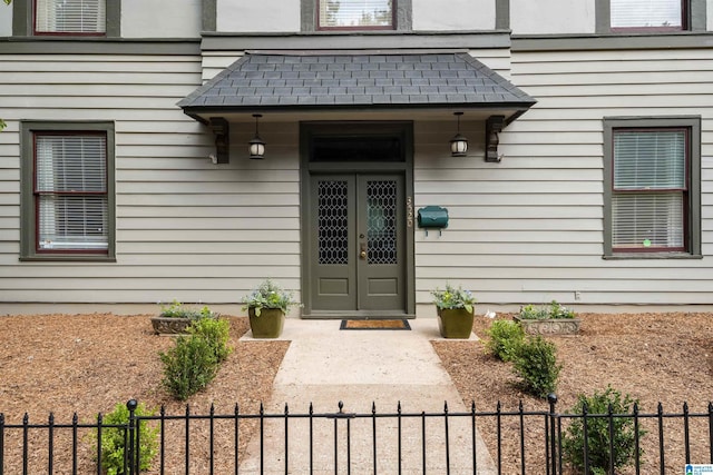 doorway to property featuring fence and french doors