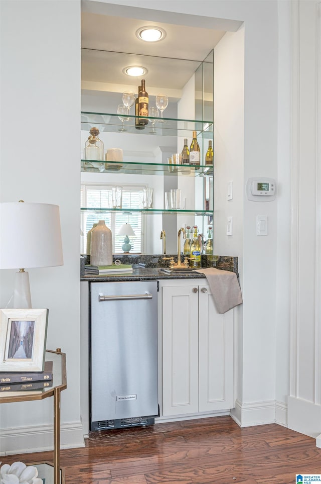 bar featuring white cabinets, dishwasher, dark hardwood / wood-style flooring, and sink