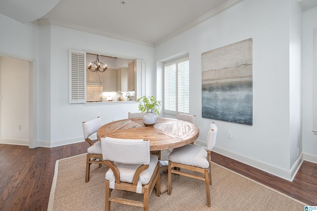 dining area with ornamental molding, dark hardwood / wood-style floors, and an inviting chandelier