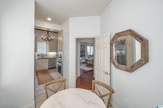 dining space featuring light hardwood / wood-style flooring, sink, and a chandelier