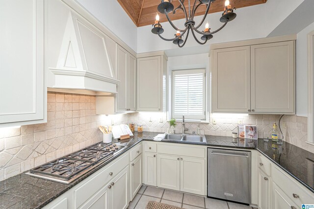 kitchen featuring stainless steel appliances, a chandelier, beamed ceiling, sink, and decorative backsplash