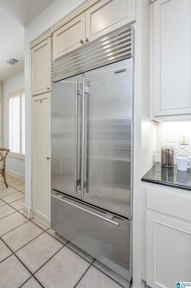 kitchen with light tile patterned floors, decorative backsplash, and stainless steel built in refrigerator