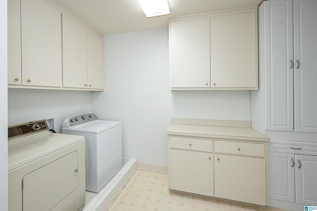 laundry room with separate washer and dryer and cabinets