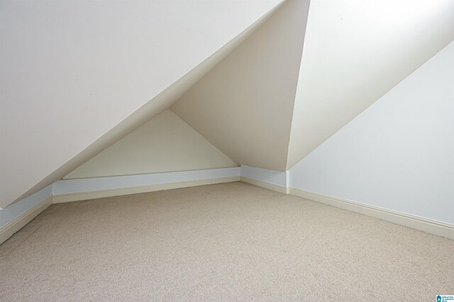 additional living space with carpet flooring and vaulted ceiling