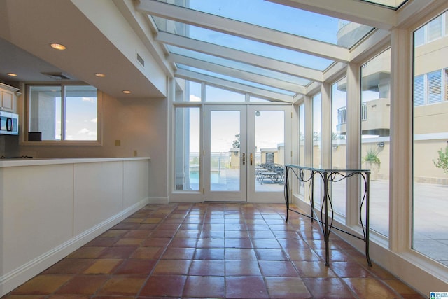 unfurnished sunroom featuring french doors and lofted ceiling with skylight