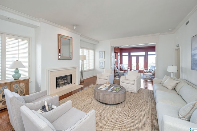 living room with ornamental molding, a premium fireplace, and hardwood / wood-style flooring