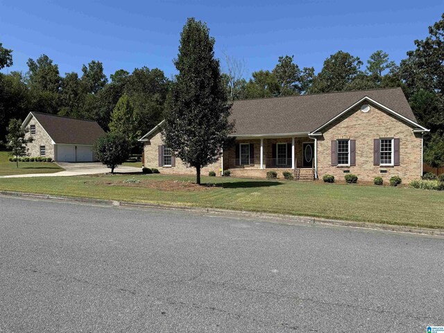 single story home with a front lawn, covered porch, brick siding, and a garage