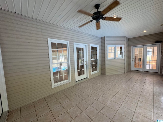 unfurnished sunroom featuring ceiling fan