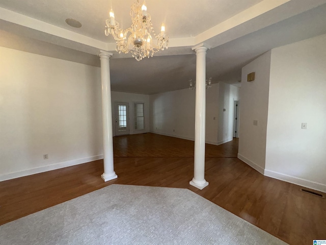 unfurnished dining area with visible vents, baseboards, wood finished floors, and a chandelier
