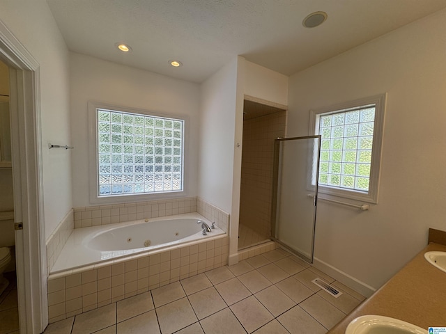 full bath with plenty of natural light, visible vents, a jetted tub, and toilet